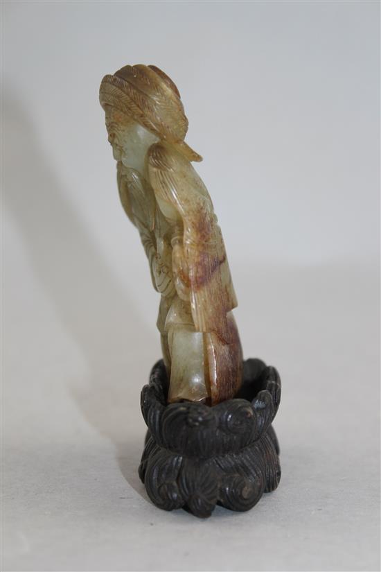 A Chinese celadon and russet skin jade figure of a fisherman, 18th / 19th century, 10cm., loss to right foot, carved wood stand